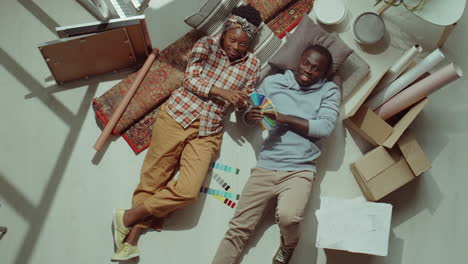 Happy-Black-Couple-Lying-on-Floor-during-Home-Renovation